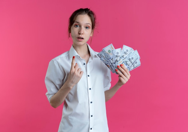 Free Photo Young Shocked Blonde Russian Girl Points Up Holding Money