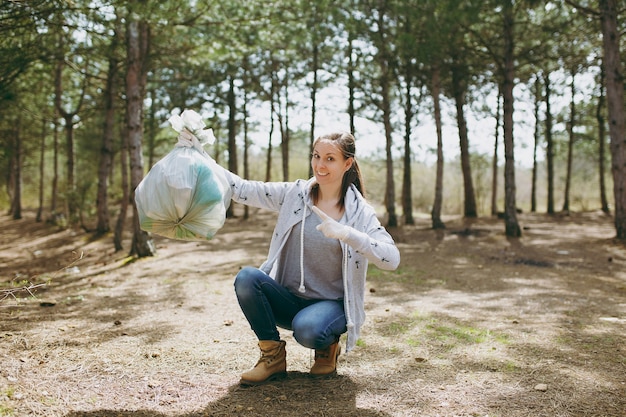 Premium Photo | Young smiling woman cleaning rubbish and pointing index ...