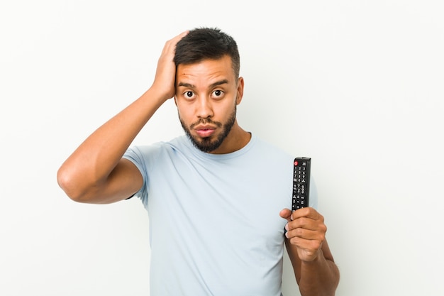 Young South Asian Man Holding A Tv Controller Being Shocked She