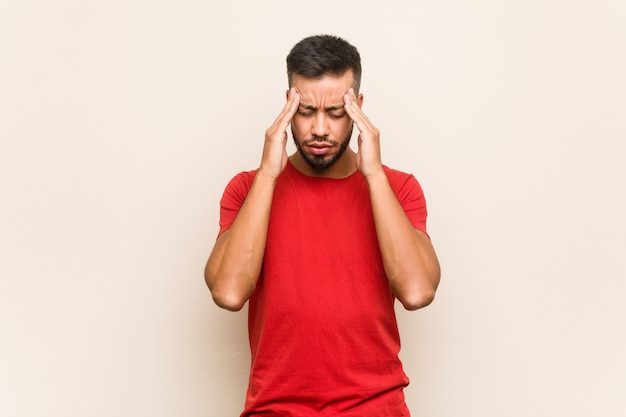 Young South Asian Man Touching Temples And Having Headache Photo