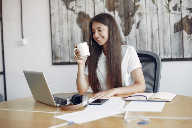 Young student sitting at the table and use the laptop Free Photo