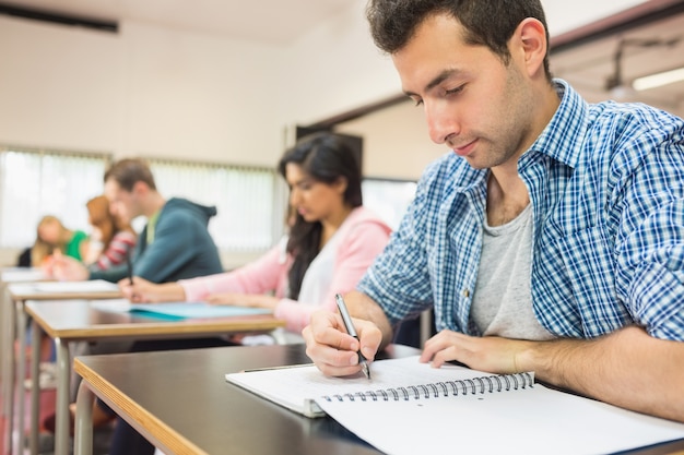 young-students-writing-notes-in-classroo