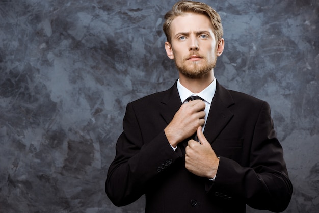 Free Photo | Young successful businessman correcting tie