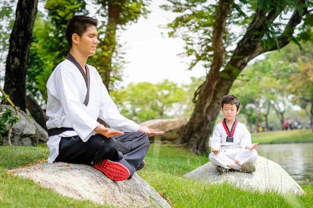 Premium Photo | Young taekwondo man and son doing meditation sitting on ...