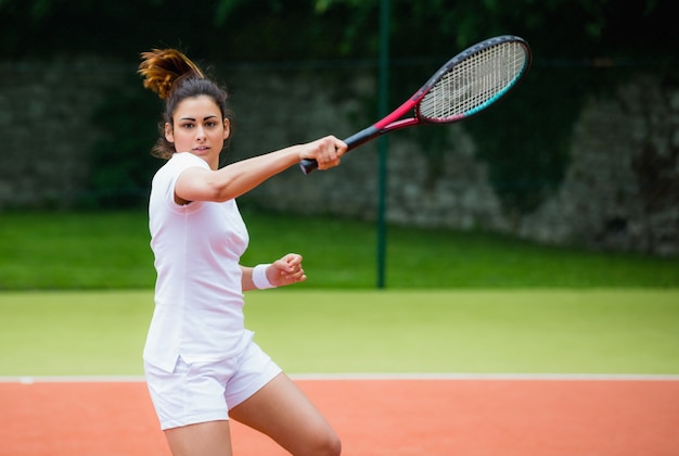 Premium Photo Young tennis player hitting ball