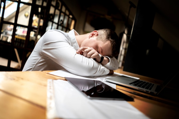 Premium Photo | Young tired worker sleep on his workplace, overwork