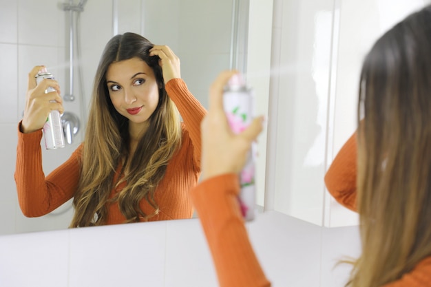 Premium Photo Young Woman Applying Dry Shampoo On Her Hair