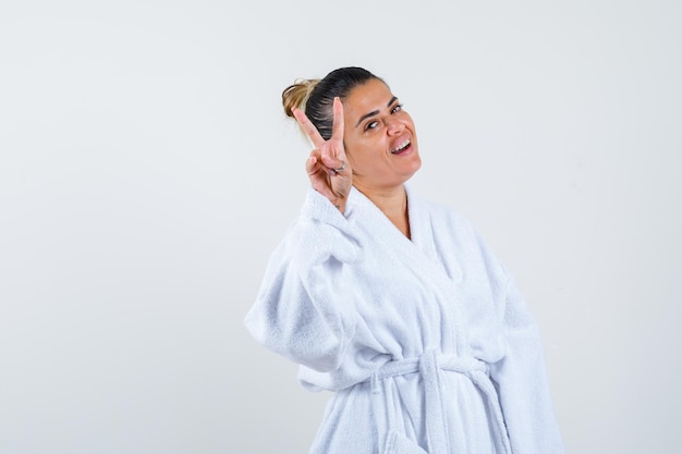 Free Photo Young Woman In Bathrobe Showing Victory Sign And Looking Lucky 1845