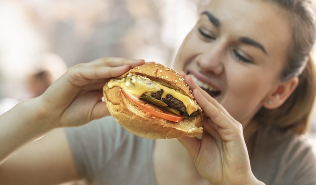 Young woman in cafe eating tasty sandwich Free Photo