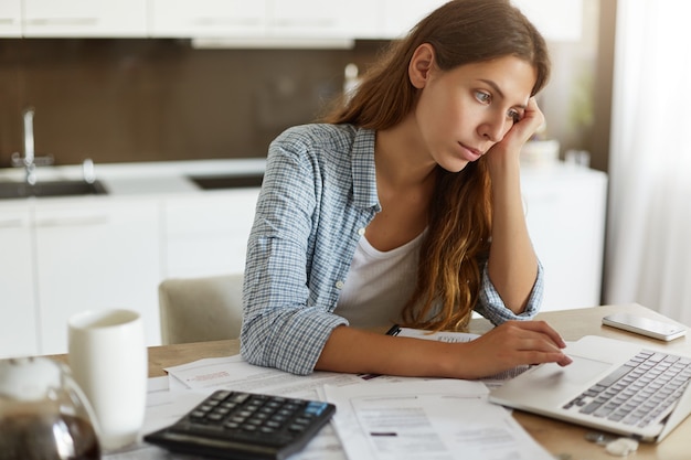 Young woman checking her budget and doing taxes Free Photo