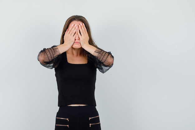 Free Photo | Young woman covering face with hands in black blouse and ...