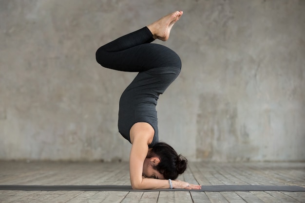 Free Photo | Young woman doing pincha mayurasana exercise