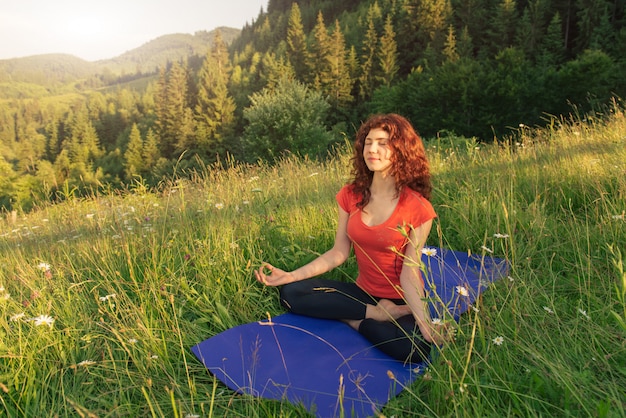 Young woman doing yoga exercises in the nature Premium Photo