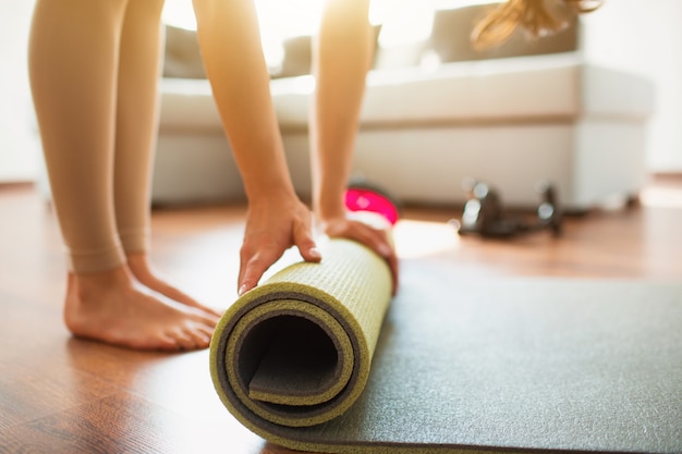 Premium Photo | Young woman doing yoga workout in room . cut low view ...