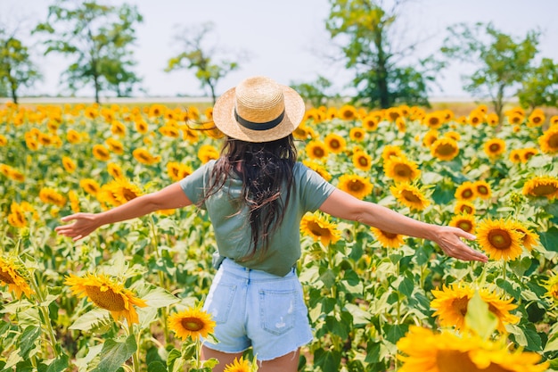 Premium Photo | Young woman enjoying nature on the field of sunflowers.