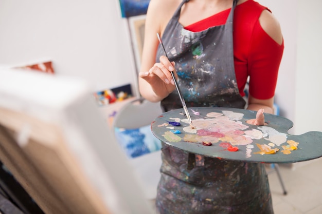 Premium Photo | Young woman enjoying painting at her art studio