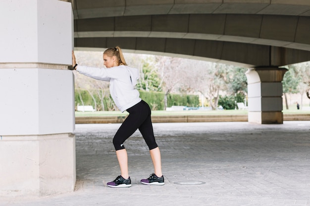 Free Photo | Young woman exercising near pillar