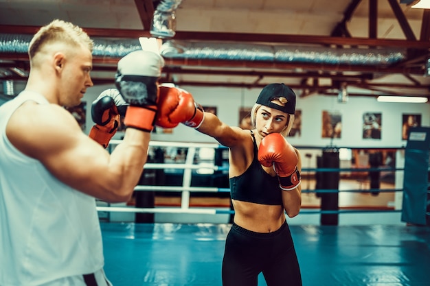 Premium Photo Young Woman Exercising With Trainer At Boxing And Self Defense Lesson