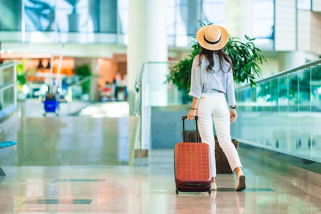 Premium Photo | Young woman in hat with baggage in international ...