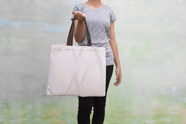 Premium Photo | Young woman holding cotton bag on wall background. eco ...