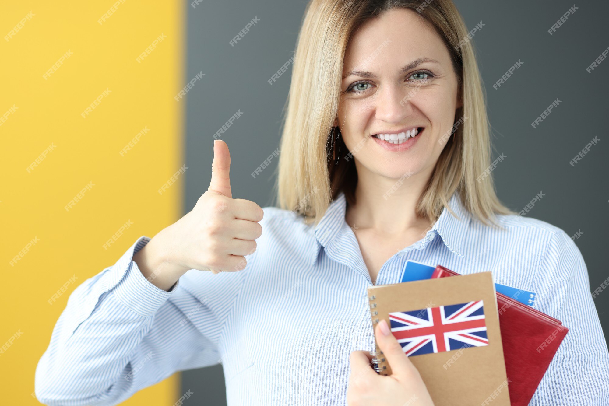 premium-photo-young-woman-holding-english-textbook-and-showing-thumb-up