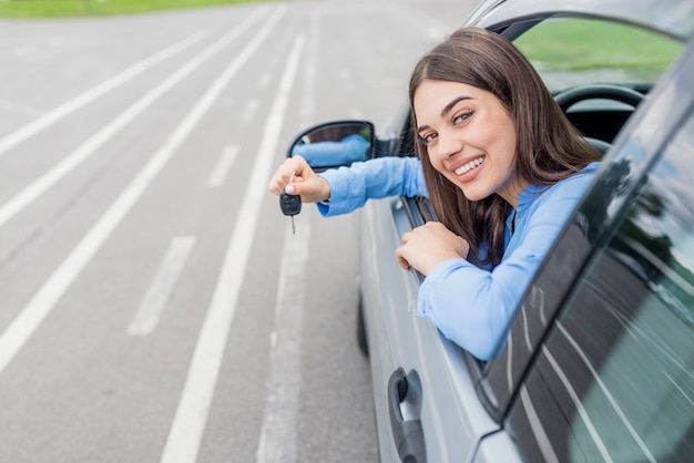 若い 女 キー 新しい 車 笑顔 カメラ プレミアム写真