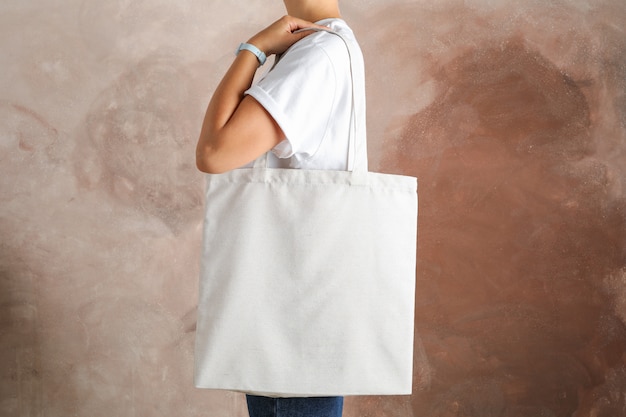 Premium Photo | Young Woman Holding Tote Bag Against Brown Background