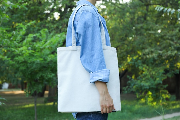 Premium Photo | Young woman holding tote bag against greenery