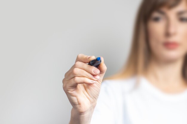 Premium Photo | Young woman holds a marker to write something