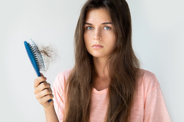 Young woman is upset because of hair loss Premium Photo