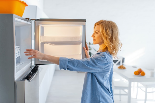 Premium Photo Young Woman Opened The Fridge On The Kitchen