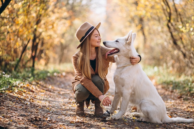 Young woman in park with her white dog Free Photo