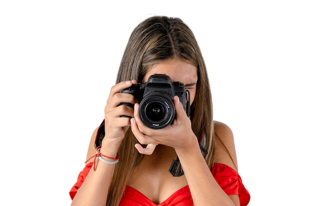 彼女のカメラを手に白い背景で写真を撮る若い女性の写真家 プレミアム写真