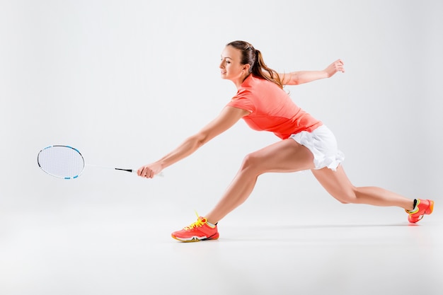 Free Photo | Young woman playing badminton over white wall