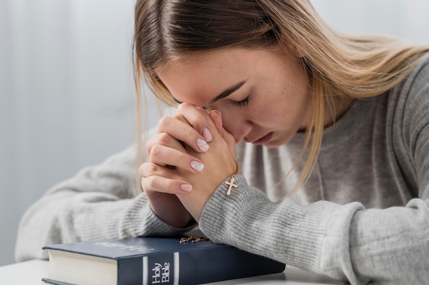 Free Photo | Young woman praying with holding cross necklace and bible