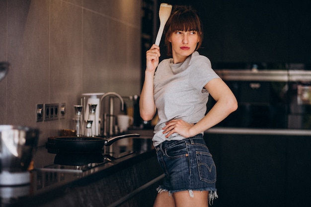 Young woman preparing breakfast in kitchen in the morning Free Photo