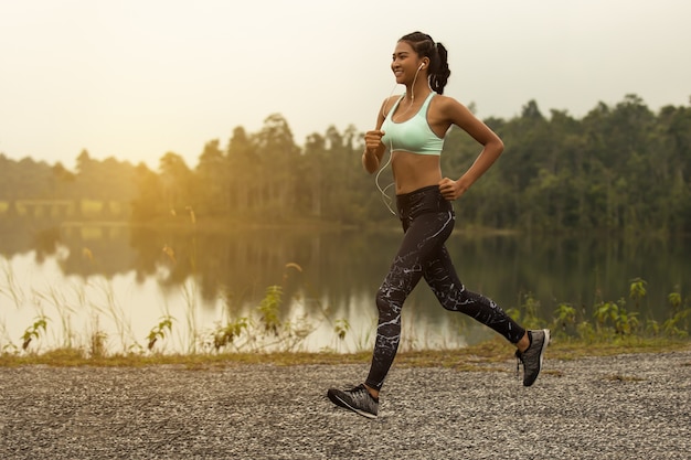 Premium Photo | Young woman running at forest trail. healthy young ...