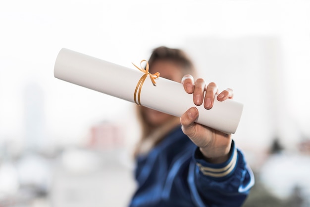 Young woman showing diploma