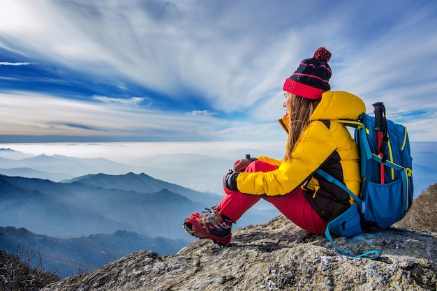 Young woman sitting on the hill of high mountains Free Photo