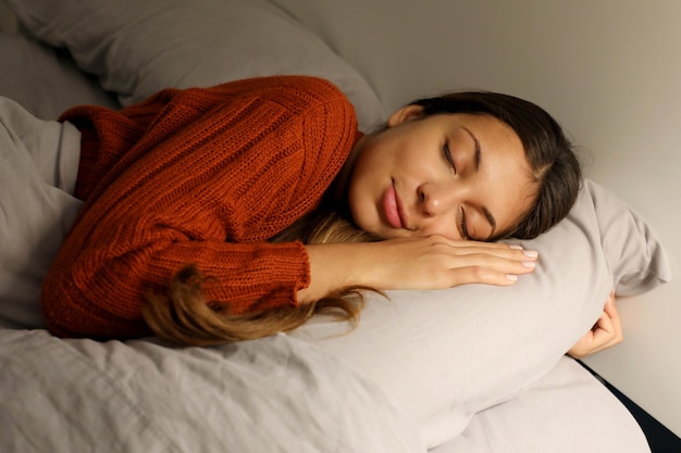 Premium Photo | Young woman sleeping peacefully on the bed