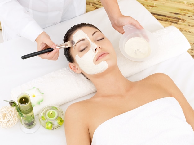 Young woman at spa salon with cosmetic mask on face. high angle photo Free Photo