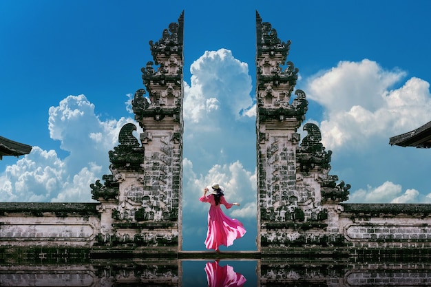 Young woman standing in temple gates at lempuyang luhur temple in bali, indonesia. vintage tone Free Photo