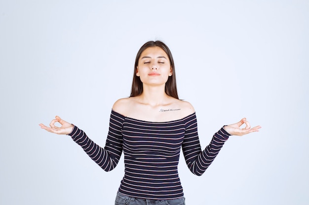 Free Photo | Young woman in striped shirt doing meditation