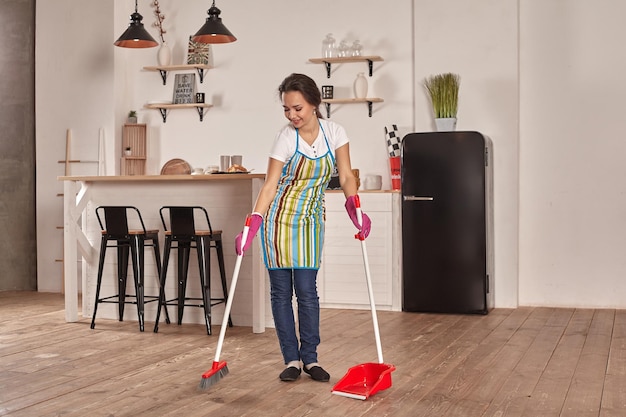 Premium Photo Young Woman Sweeping Floor On The Kitchen