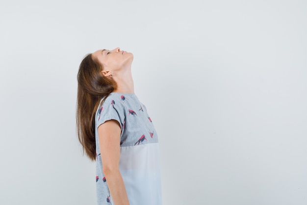 free-photo-young-woman-tilting-back-her-head-in-t-shirt-and-looking