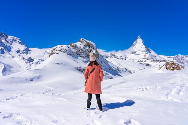 冬の日 ツェルマット スイスの雪山マッターホルンピークを楽しむ若い女性観光客 プレミアム写真