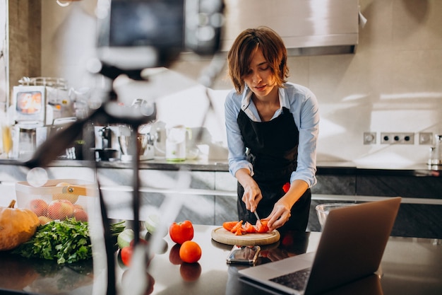 Young woman videoblogger cooking at the kitchen and filming Free Photo