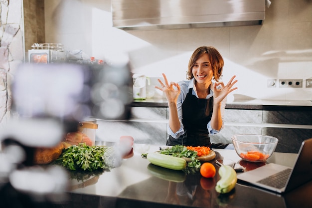 Young woman videoblogger cooking at the kitchen and filming Free Photo