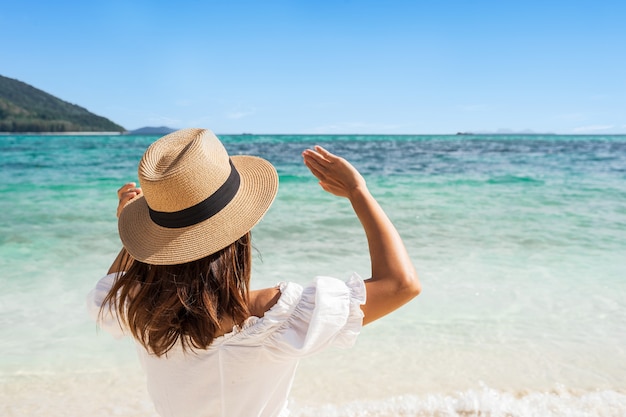 Premium Photo | Young woman in white dress and straw hat raising her ...