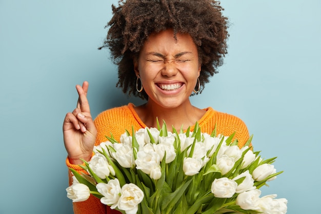 Free Photo | Young woman with afro haircut holding bouquet of white flowers